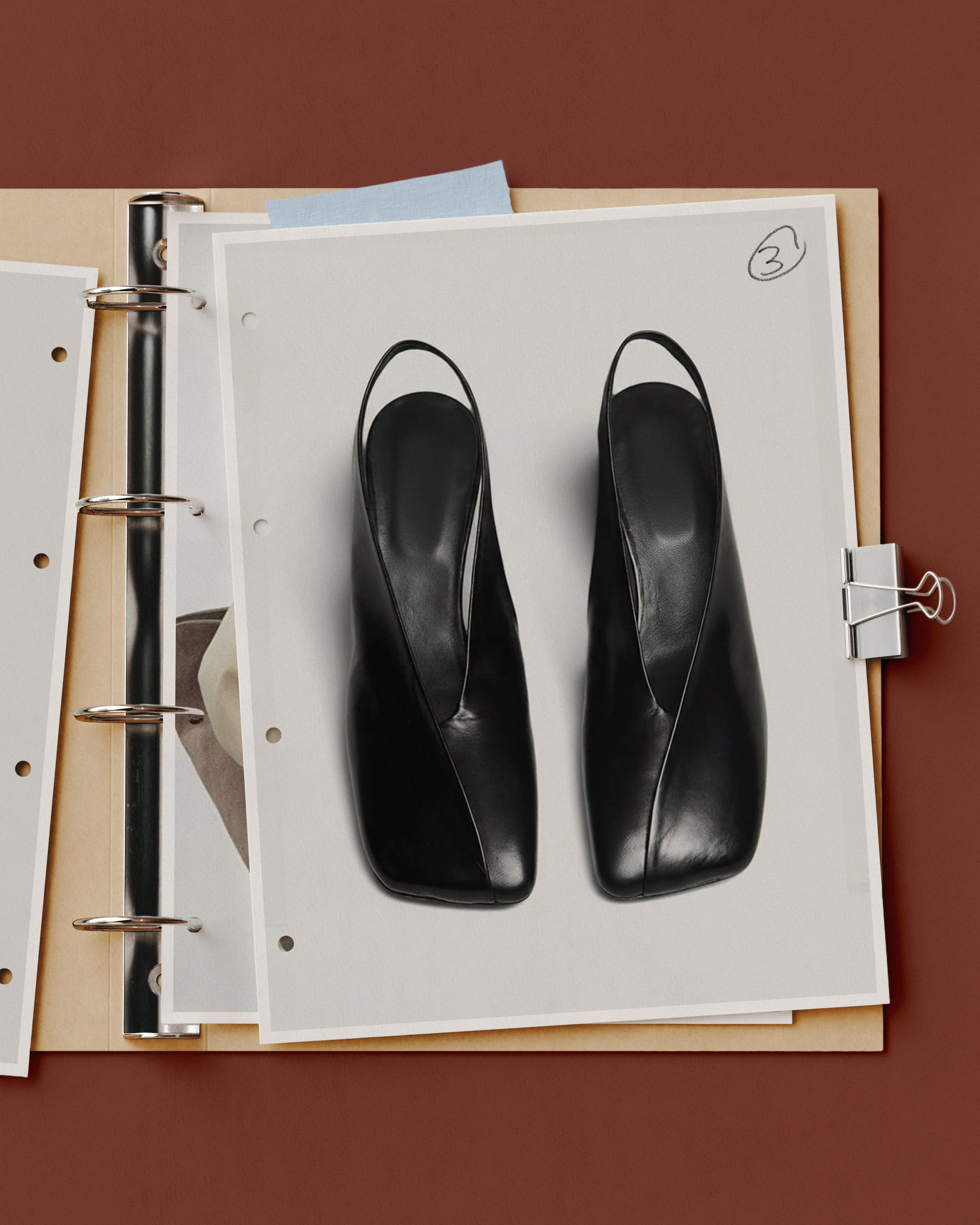 Fashion journal mockup with black slingback heels on punched binder pages held by a silver clip