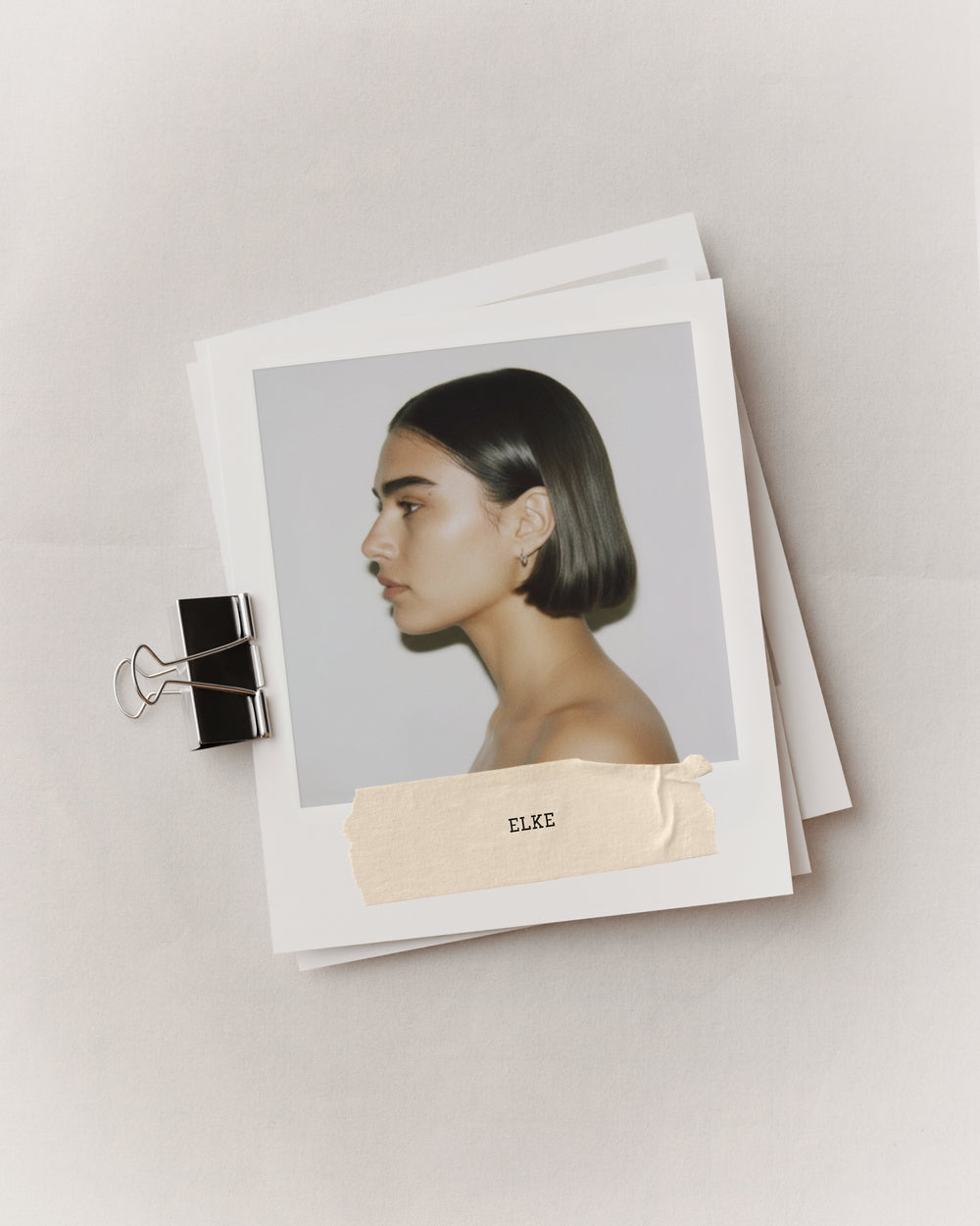 Fashion journal mockup with binder clip, stacked pages, model profile portrait, and taped label by October November